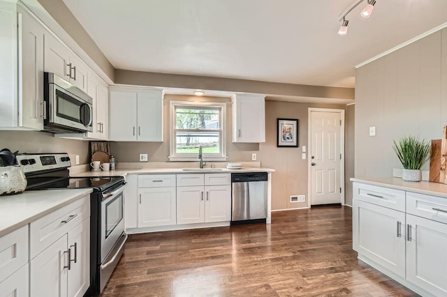 kitchen featuring appliances with stainless steel finishes, a sink, white cabinetry, and light countertops