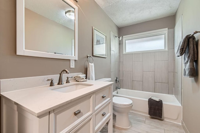bathroom with a textured ceiling, toilet, vanity, and bathtub / shower combination