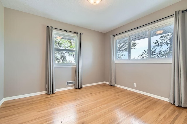 spare room with light wood-style flooring and baseboards