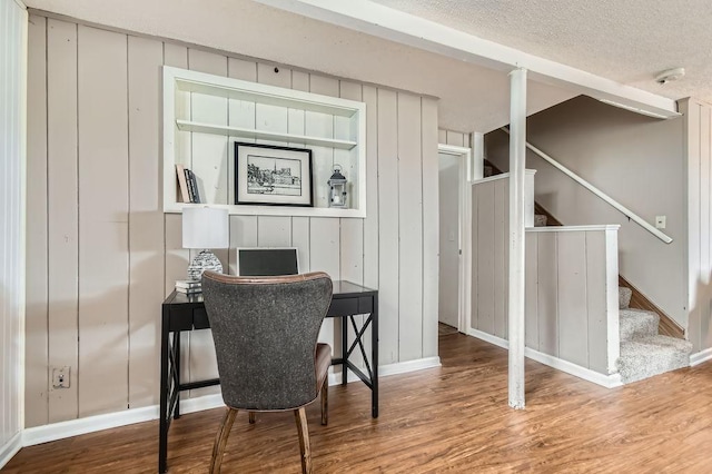 office with wood finished floors, baseboards, and a textured ceiling