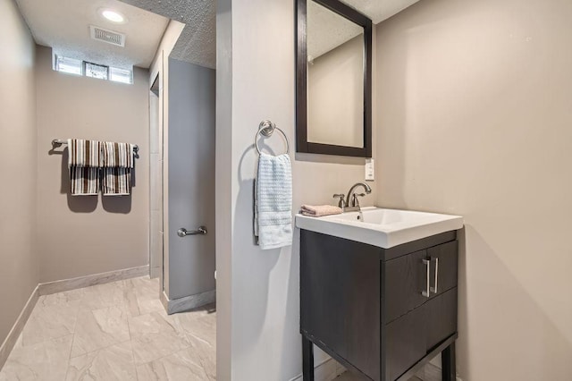 bathroom with baseboards, marble look tile flooring, and vanity