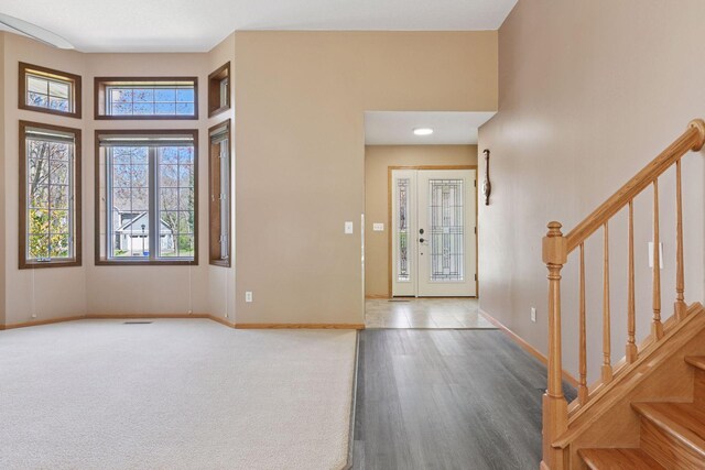 entryway with baseboards, wood finished floors, and stairway