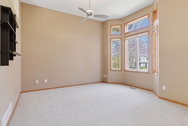 unfurnished room featuring baseboards, ceiling fan, and light carpet