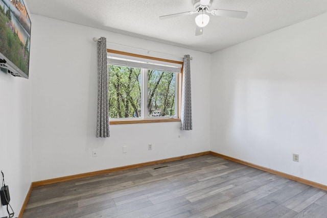 spare room featuring baseboards, a ceiling fan, and wood finished floors