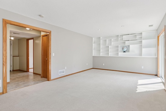empty room featuring baseboards, carpet, and visible vents