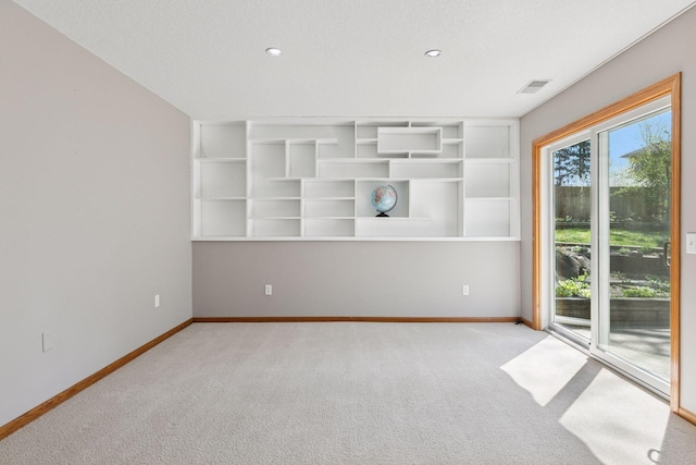 empty room with baseboards, carpet flooring, recessed lighting, and built in shelves