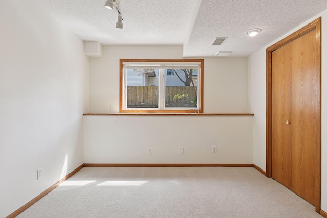 unfurnished bedroom with carpet floors, baseboards, a textured ceiling, and visible vents