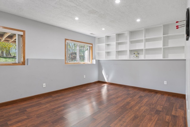 unfurnished room with a textured ceiling, recessed lighting, and wood finished floors