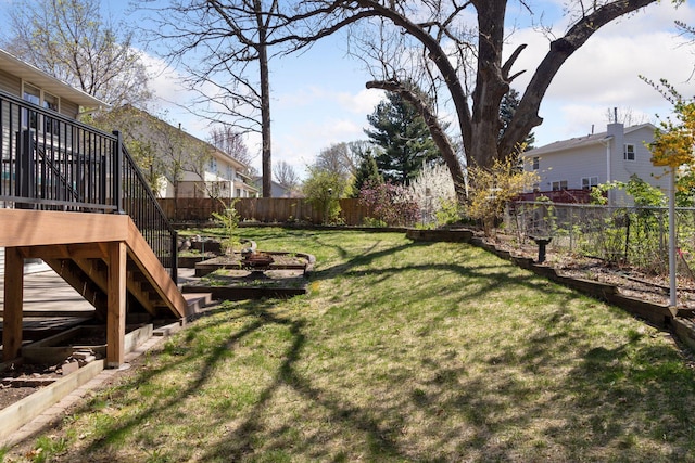 view of yard featuring a fenced backyard, a deck, and stairway