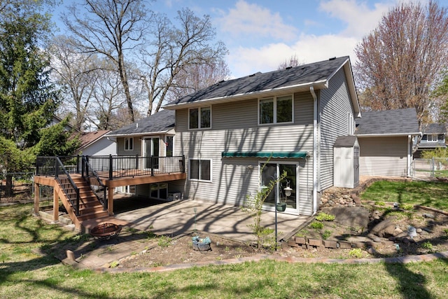 rear view of house featuring roof with shingles, a deck, a patio, a fire pit, and stairs