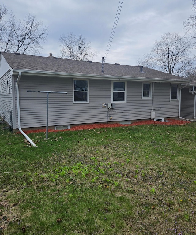 rear view of property featuring a yard