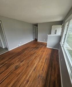 unfurnished room featuring baseboards and wood finished floors