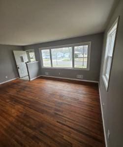 interior space with baseboards and dark wood-style flooring