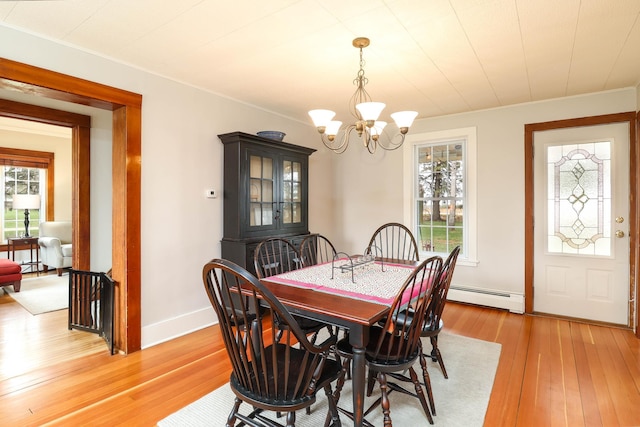dining room with ornamental molding, light wood-style floors, baseboards, baseboard heating, and a chandelier