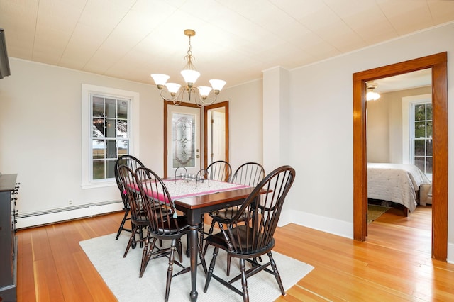 dining room with crown molding, light wood-style flooring, a baseboard heating unit, and a chandelier
