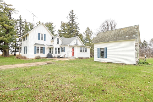 view of front facade featuring a patio, entry steps, and a front lawn