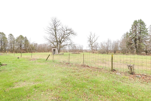 view of yard with fence and a rural view