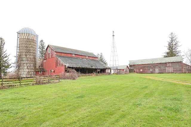 view of yard featuring fence, a barn, and an outdoor structure