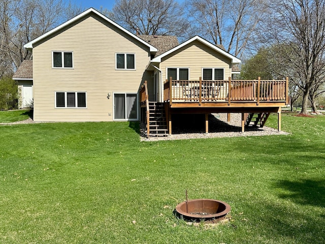 back of house with a lawn, roof with shingles, a wooden deck, and stairway