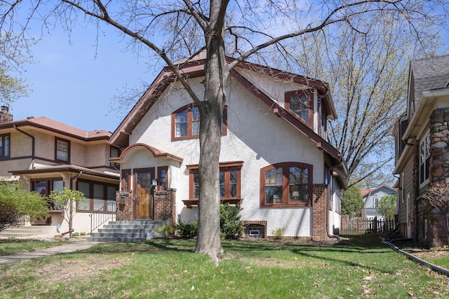 view of front of property with brick siding, a front lawn, and stucco siding