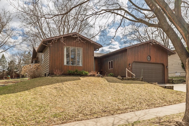 view of front of property featuring an attached garage, driveway, and a front yard