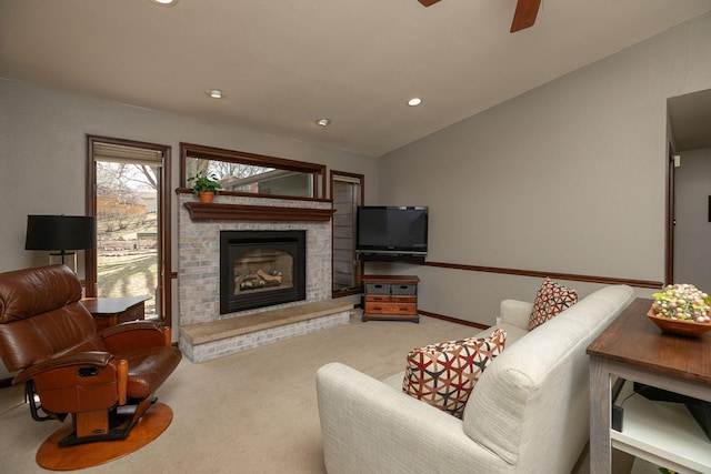 carpeted living area featuring ceiling fan, a fireplace, baseboards, lofted ceiling, and recessed lighting