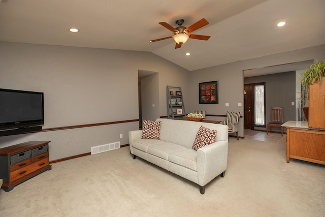 living room with ceiling fan, light carpet, vaulted ceiling, and visible vents