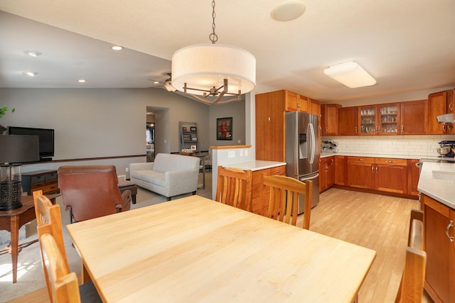 dining area with light wood-style floors, recessed lighting, ceiling fan with notable chandelier, and vaulted ceiling