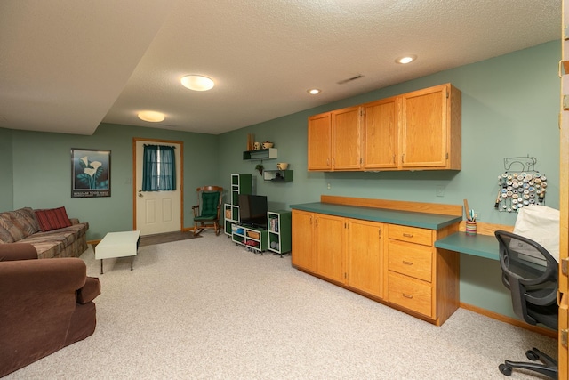 interior space featuring light colored carpet, built in study area, a textured ceiling, recessed lighting, and baseboards