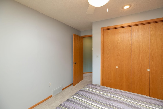 carpeted bedroom featuring baseboards, a ceiling fan, a closet, and visible vents