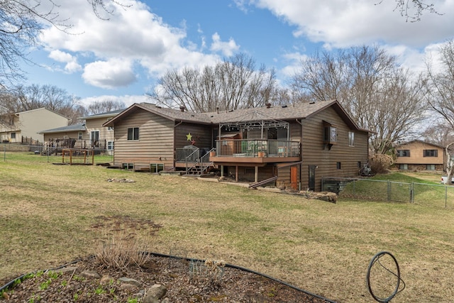 rear view of house with a fenced backyard, a wooden deck, and a lawn