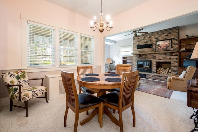 106 4th St, Cyrus, MN 56323 - dining area featuring a fireplace, light carpet, and ceiling fan with notable chandelier