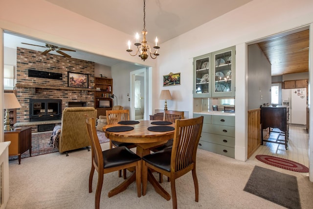 106 4th St, Cyrus, MN 56323 - dining area featuring light colored carpet, a fireplace, and ceiling fan with notable chandelier