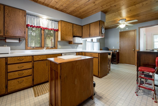 106 4th St, Cyrus, MN 56323 - kitchen with a peninsula, a sink, brown cabinetry, white appliances, and a kitchen island