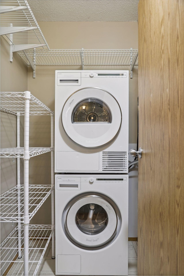 clothes washing area featuring stacked washer / drying machine and laundry area