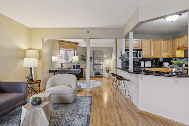 living area featuring light wood-style floors and baseboards