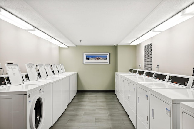 community laundry room featuring baseboards and washer and clothes dryer