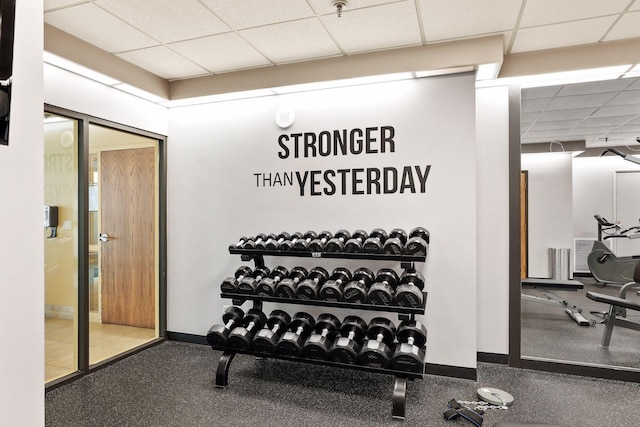 workout room with baseboards and a paneled ceiling