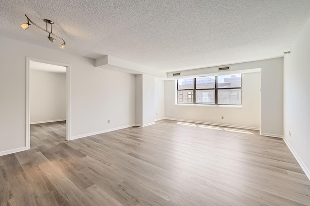 401 1st St Unit 414, Minneapolis, MN 55401 - unfurnished room with a textured ceiling, light wood-style flooring, and baseboards