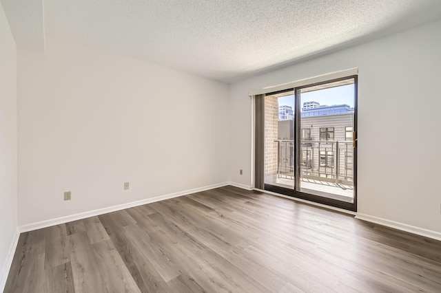 401 1st St Unit 414, Minneapolis, MN 55401 - unfurnished room featuring wood finished floors, a textured ceiling, and baseboards