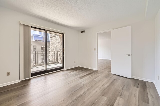 401 1st St Unit 414, Minneapolis, MN 55401 - spare room featuring wood finished floors, a textured ceiling, and baseboards