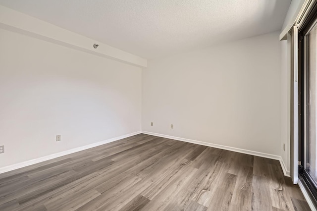 401 1st St Unit 414, Minneapolis, MN 55401 - unfurnished room featuring dark wood-style flooring, a textured ceiling, and baseboards