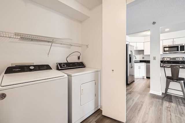 401 1st St Unit 414, Minneapolis, MN 55401 - laundry area featuring washer and dryer and light wood-style flooring