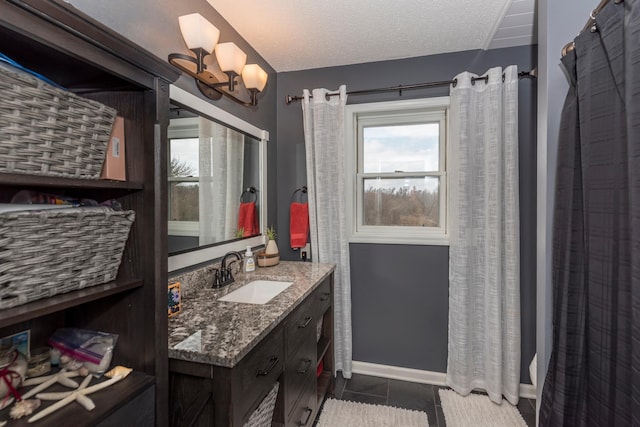 full bath with vanity, tile patterned flooring, and a textured ceiling