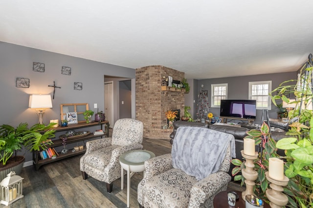 living room with baseboards, wood finished floors, and a fireplace