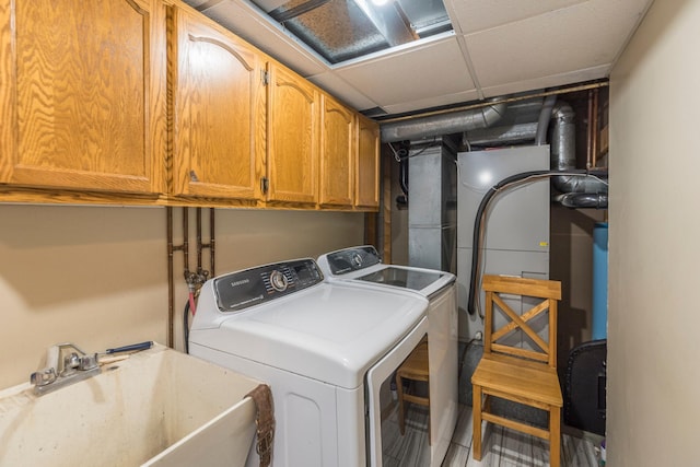 washroom featuring a sink, cabinet space, and washer and dryer