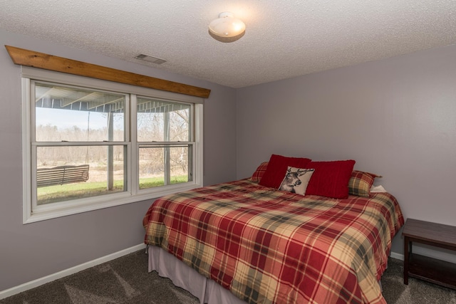 carpeted bedroom with visible vents, a textured ceiling, and baseboards