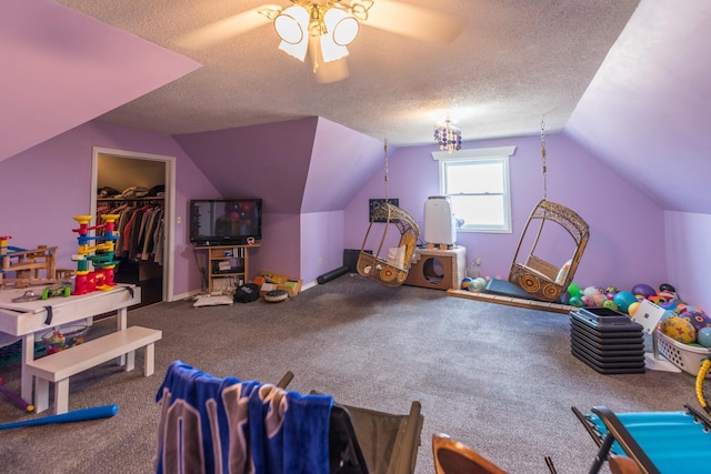 recreation room featuring ceiling fan, a textured ceiling, carpet floors, baseboards, and lofted ceiling