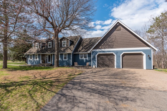 view of front of home featuring an attached garage, a front lawn, and aphalt driveway