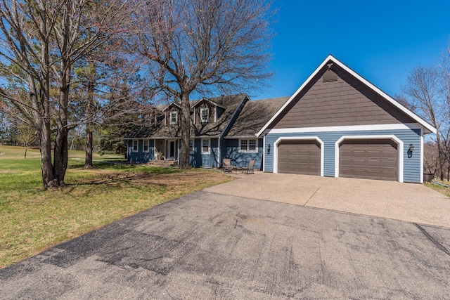 view of front of house featuring an attached garage, a front lawn, and driveway